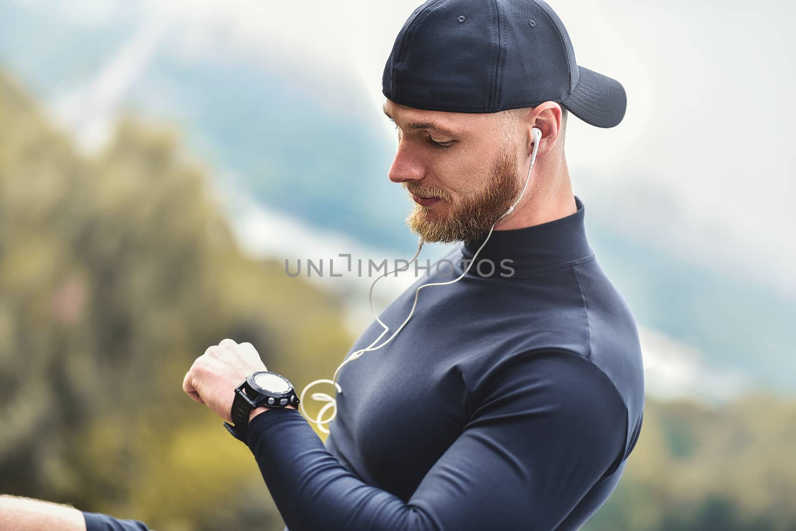 Close-up Shot Bearded Sportive Man After Workout Session Checks Fitness Results. Adult Guy Wearing Sport Tracker Wristband.