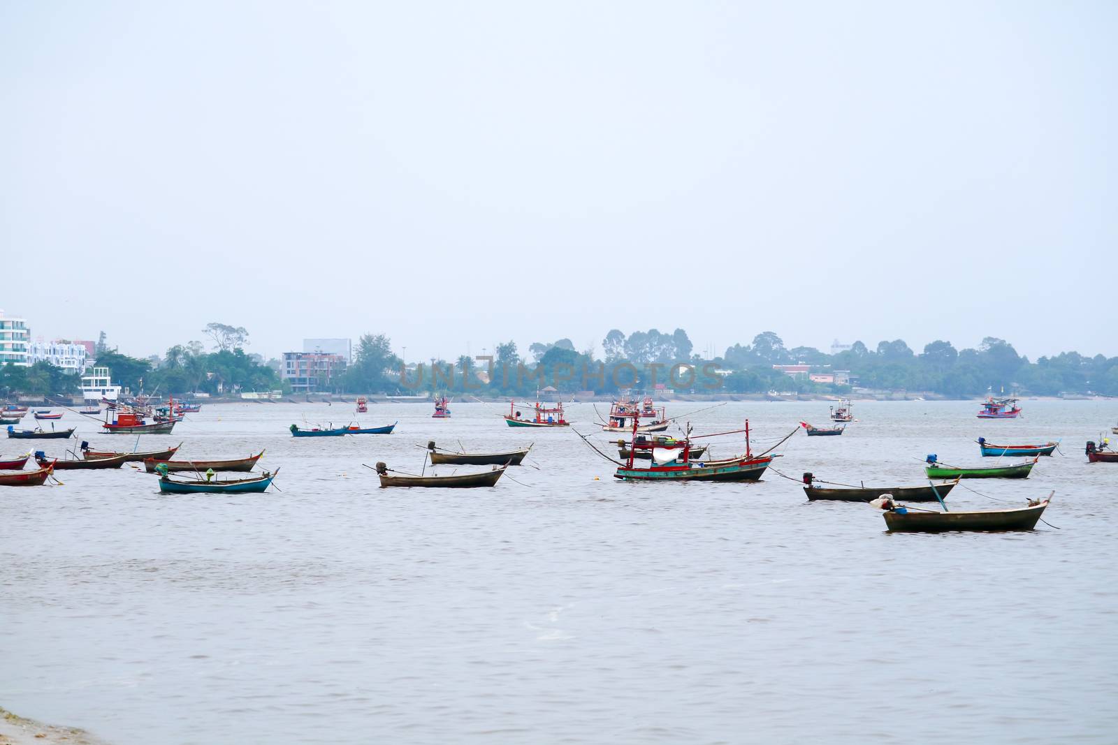 Fishing boats are anchored near the shore as a storm warning and strong winds