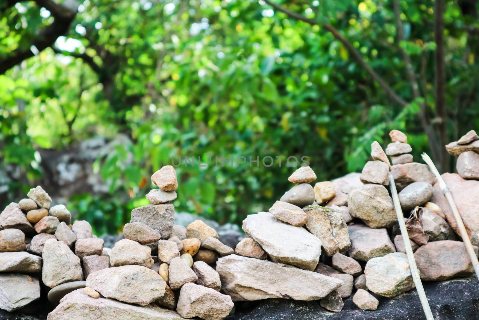 rock is arranged as a pagoda for worship of lord buddha and forest nature background