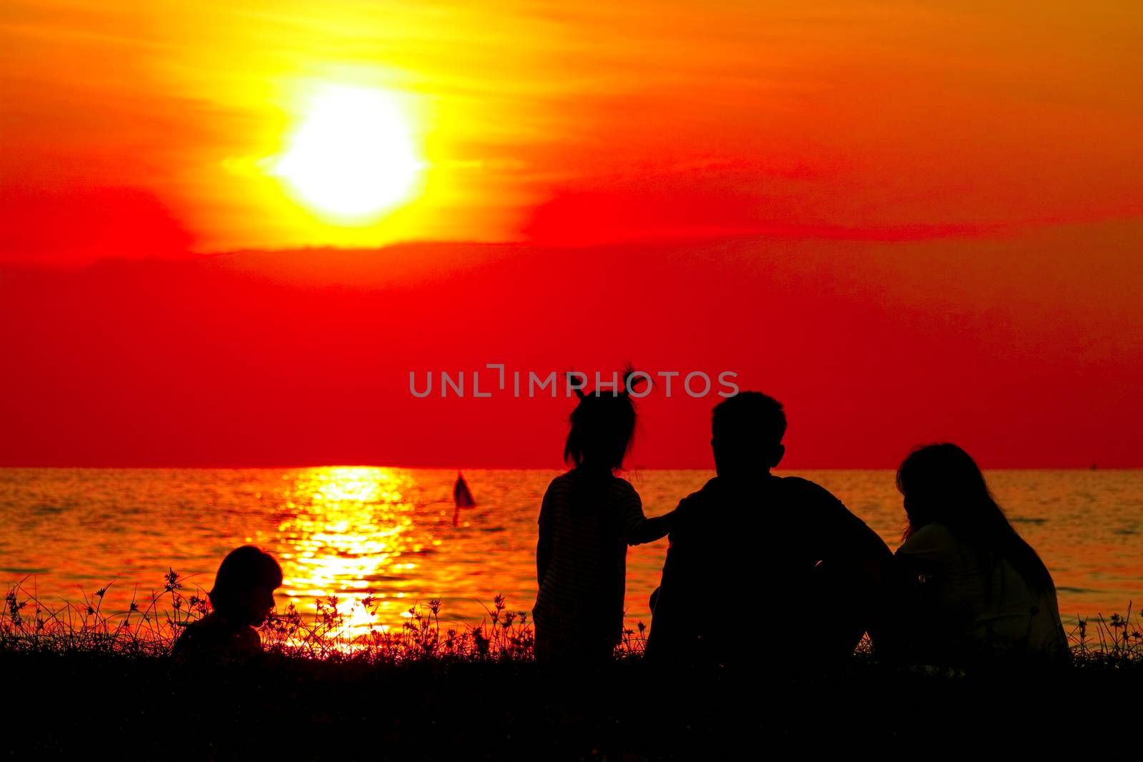 silhouette family on beach blurred sunset sky on the sea