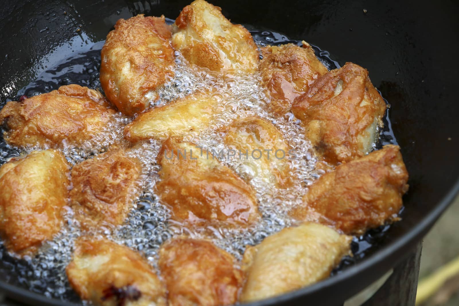 Fried chicken in a pan with hot oil. Golden yellow fried chicken in a pan.