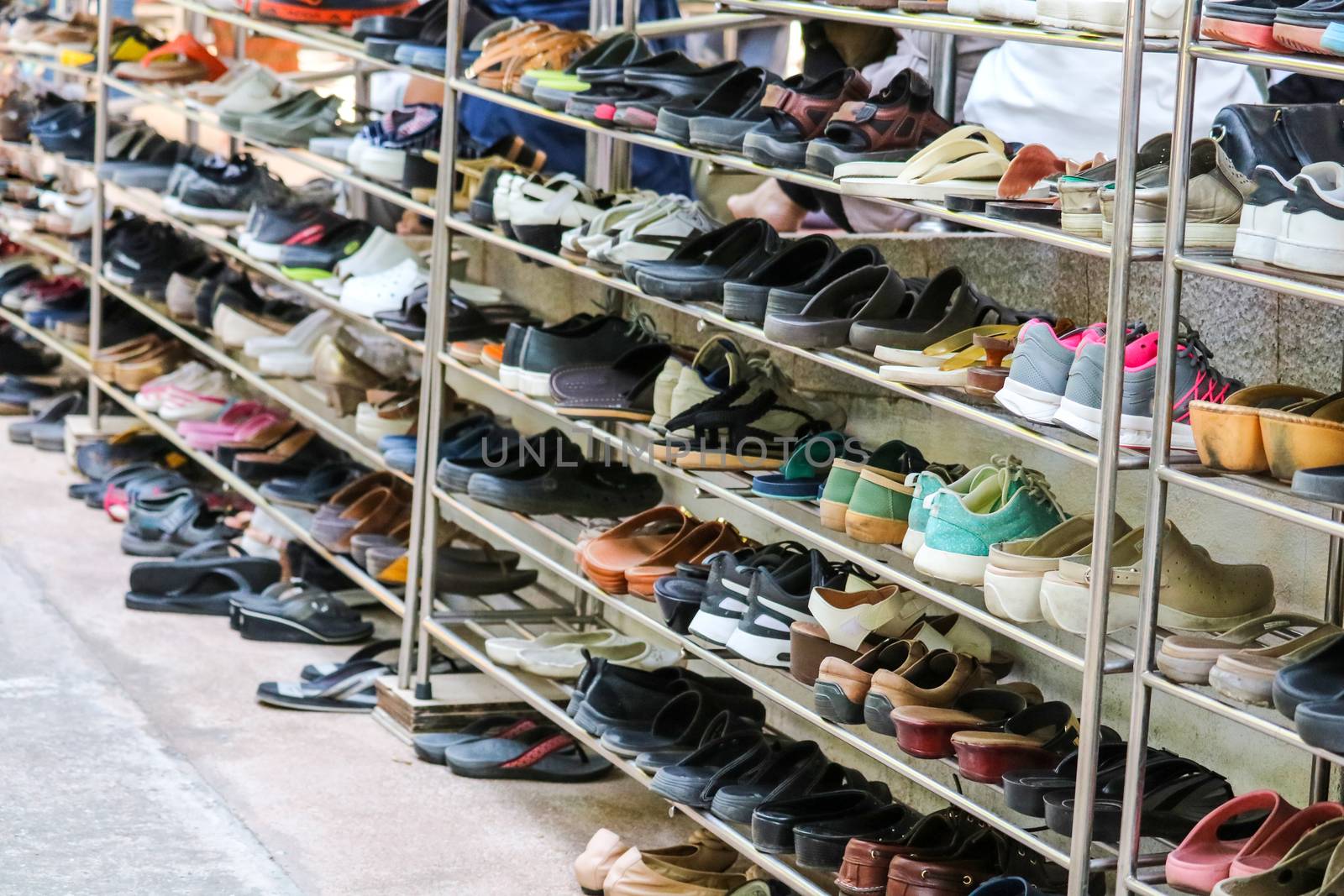 Shoes are organized in an orderly manner on the shelves inside a temple