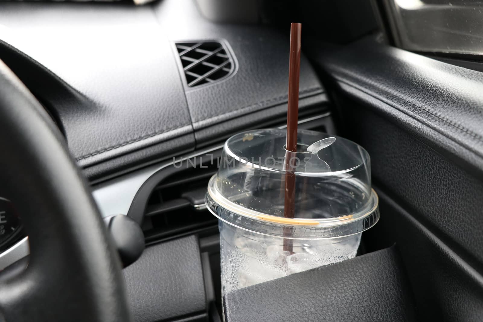 Coffee cups placed in the cup holder next to the car steering wheel. by Eungsuwat