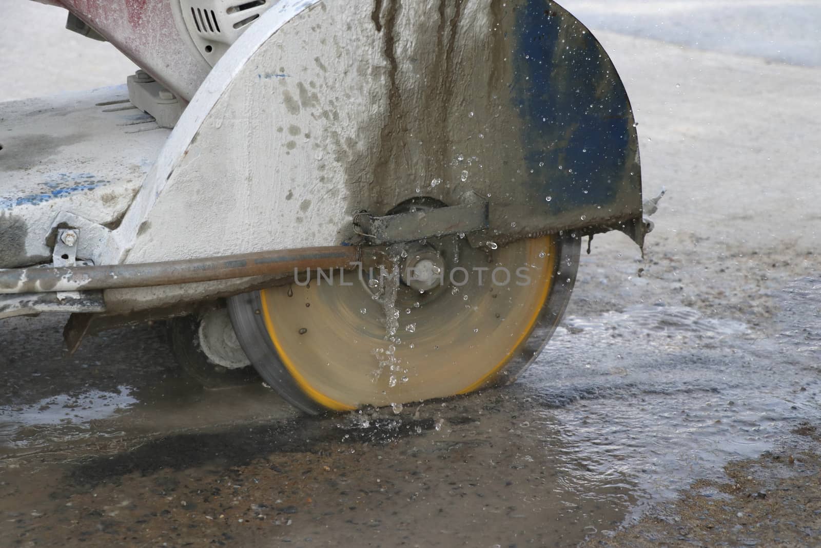 Concrete cutting machine are cutting concrete floor using cast water to reduce dust spread.