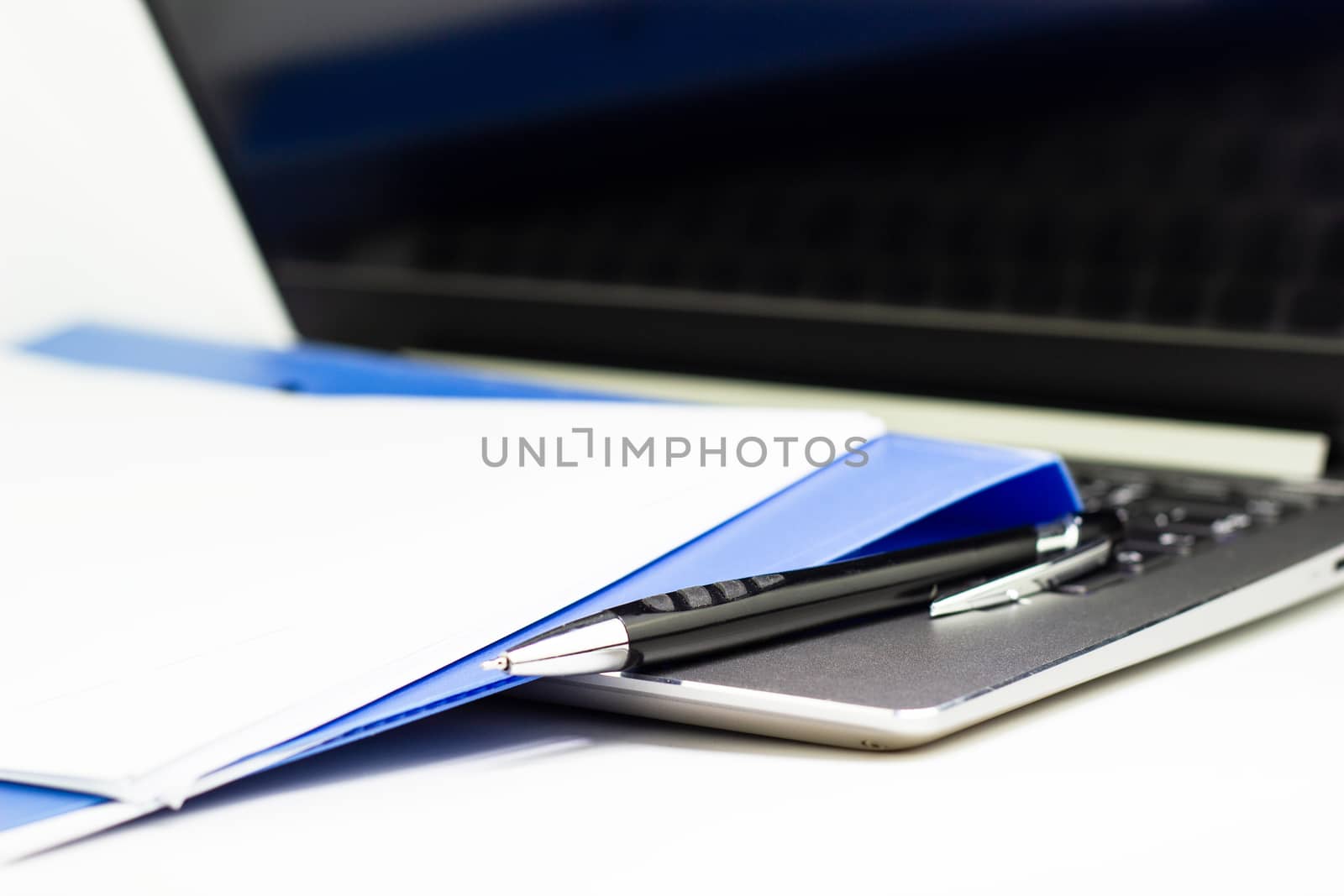 Close Up Blue file folder and Laptop Computer on desk in meeting by piyaphun
