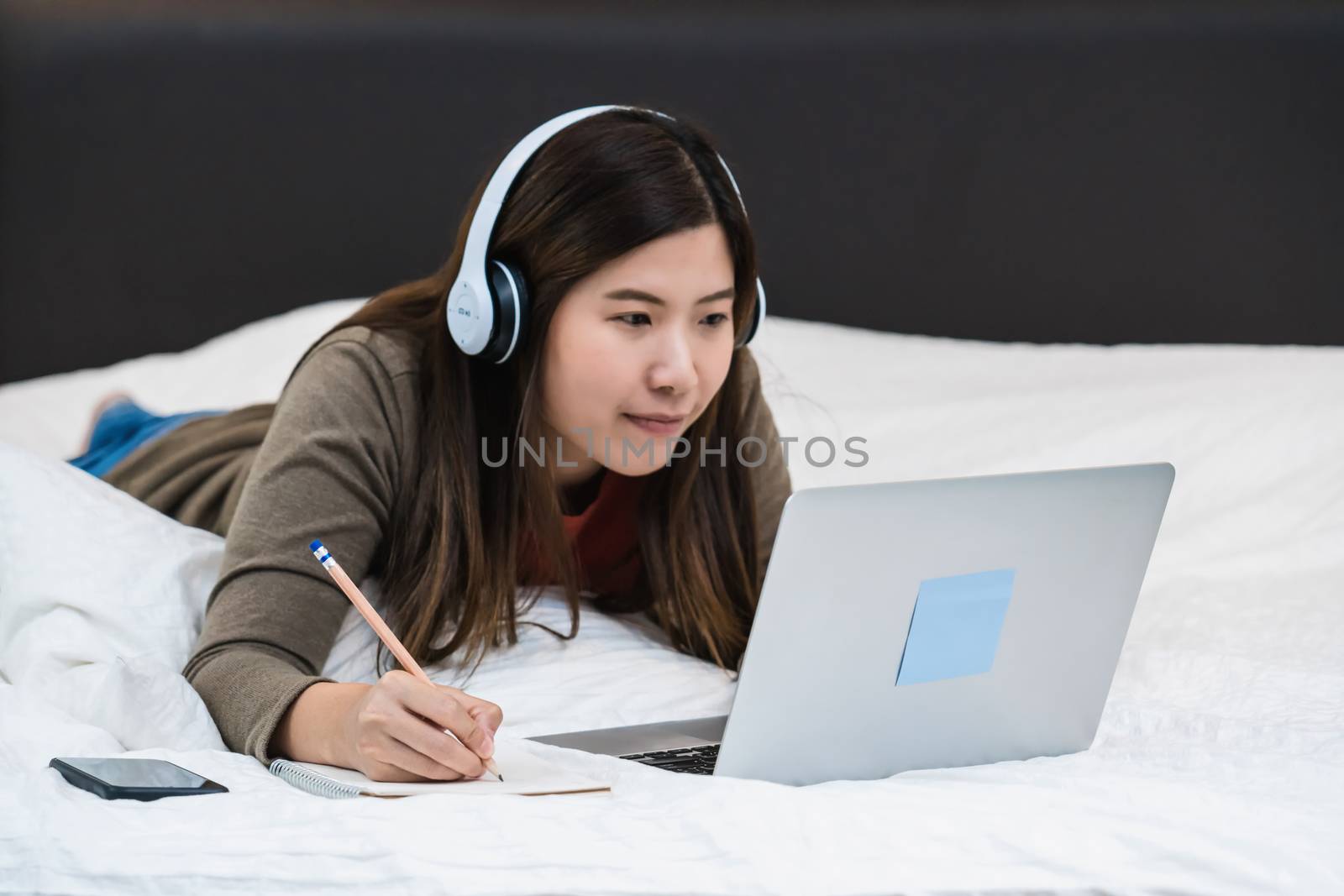 Closeup Asian business woman hand writing and using technology laptop for work from home in bedroom,freelance and entrepreneur, startups and business owner, social distance and responsibility