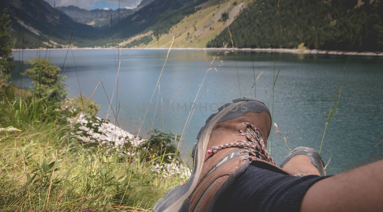 hiker taking a break sitting near the lake of Oule in Pyrenees,  by AtlanticEUROSTOXX