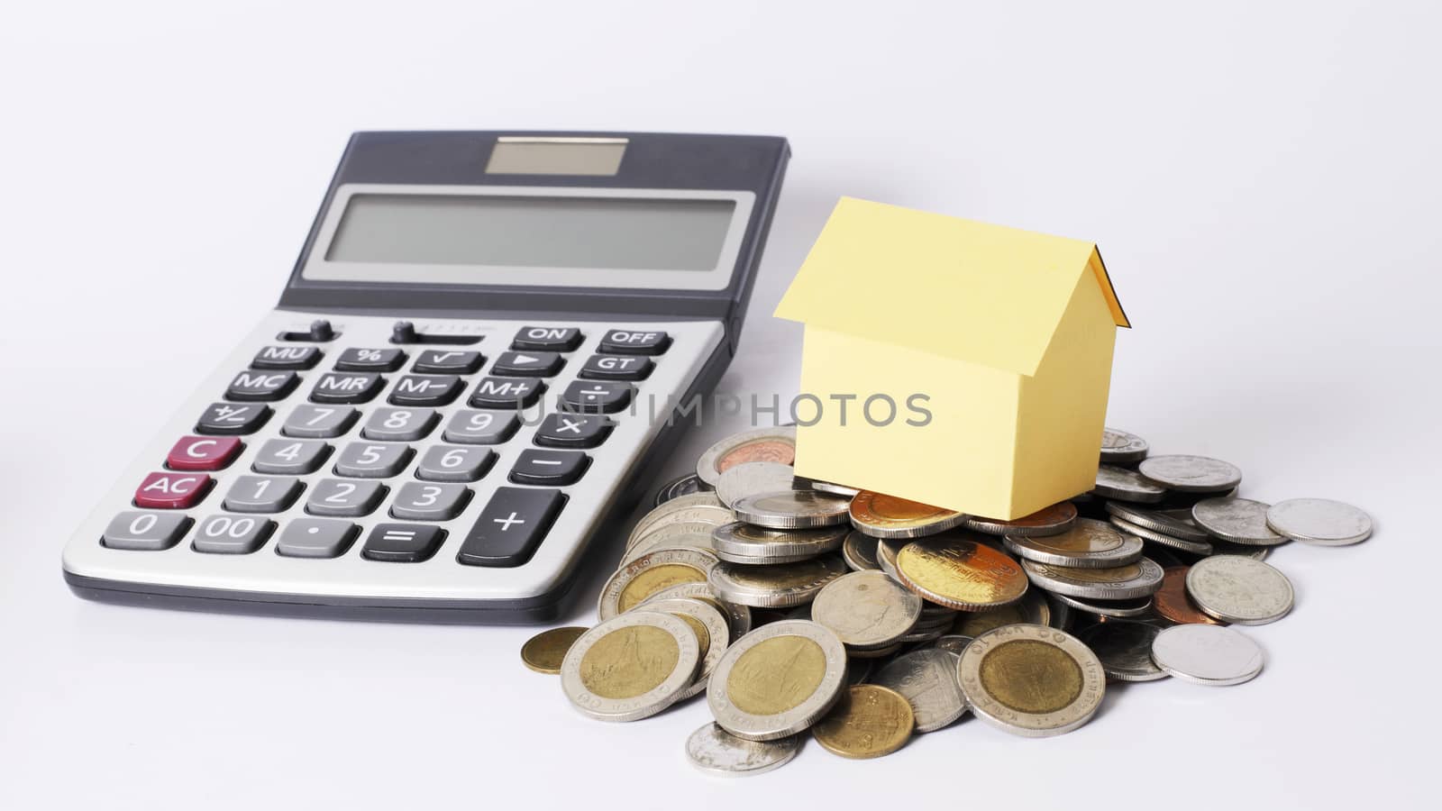 Close up for yellow house and coins stack and Calculator