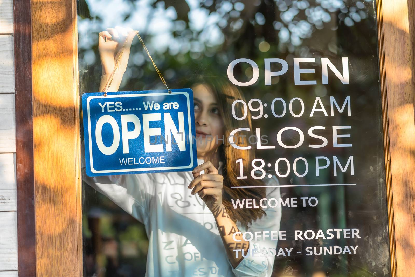 Closeup Asian young asian woman setting open sign at the shop glasses for welcome the customer in to the coffee shop, small business owner and startup with cafe shop, installing open and close concept