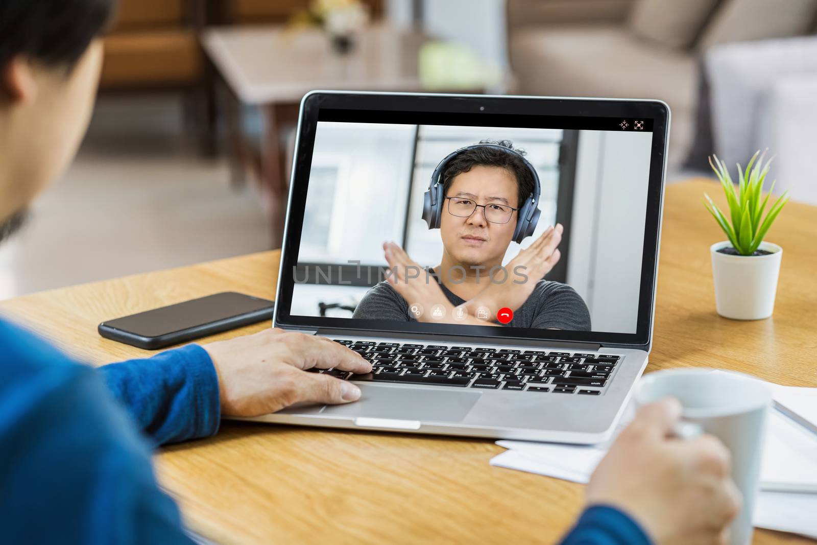 Asian Business man meeting and voting no with teamwork colleague in video call conference screen when Covid-19 pandemic,Coronavirus outbreak,online meeting,Social distancing and new normal concept