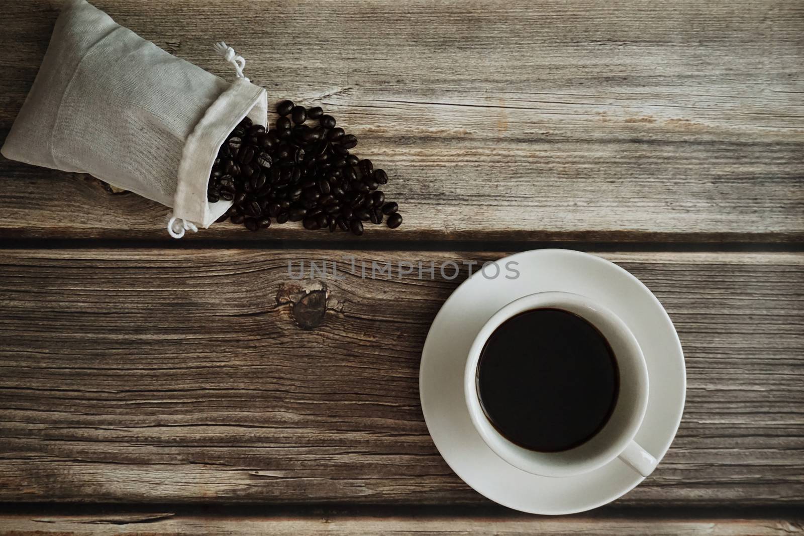 A cup of Espresso with roasted coffee bean on wooden table.