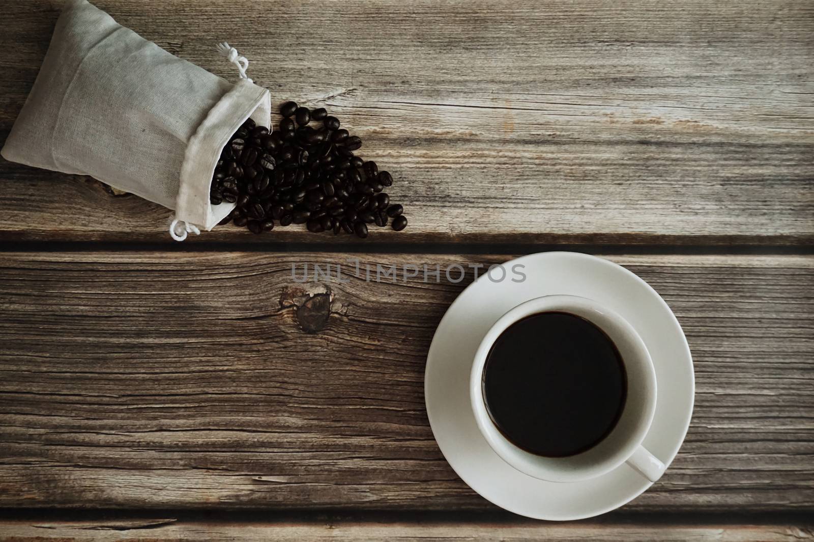 A cup of Espresso with roasted coffee bean on wooden table. by Urvashi-A