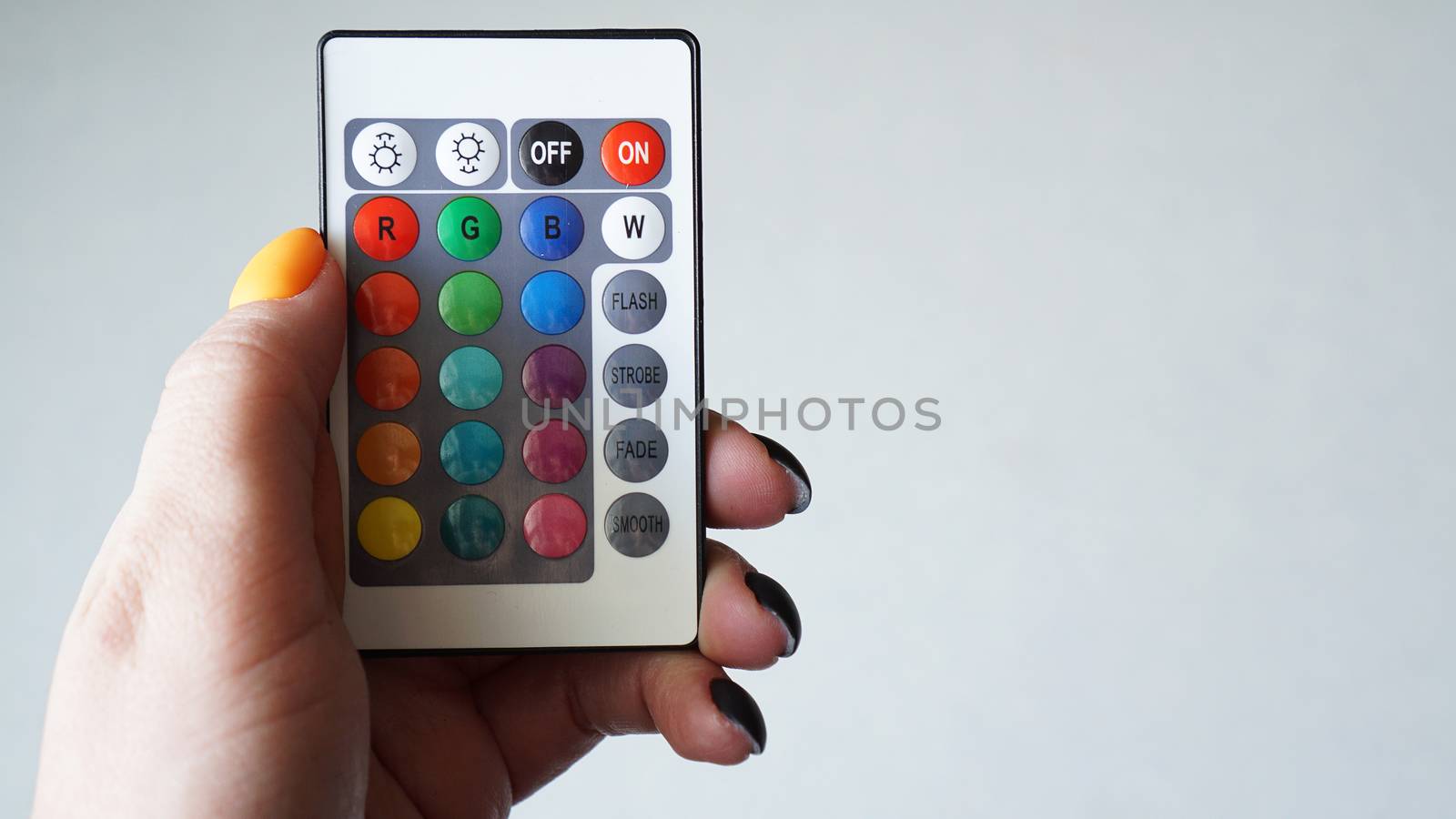 Remote control for change colors in hand isolated on white by natali_brill