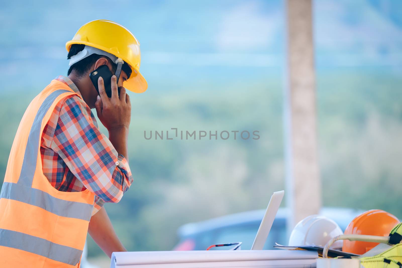 Construction worker talking on the phone at the construction sit by Visoot