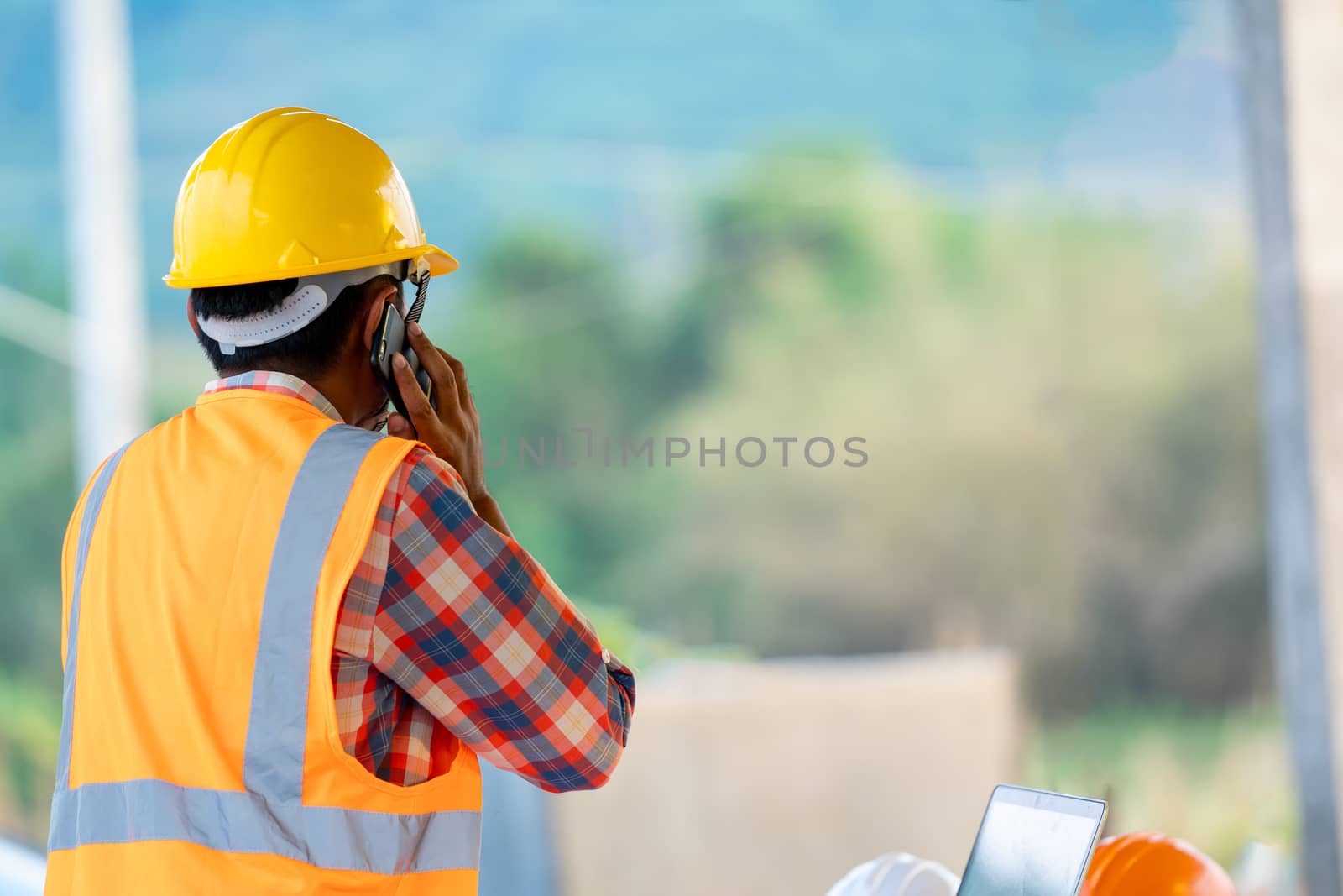 Construction worker talking on the phone at the construction site,Engineer,Construction concept.