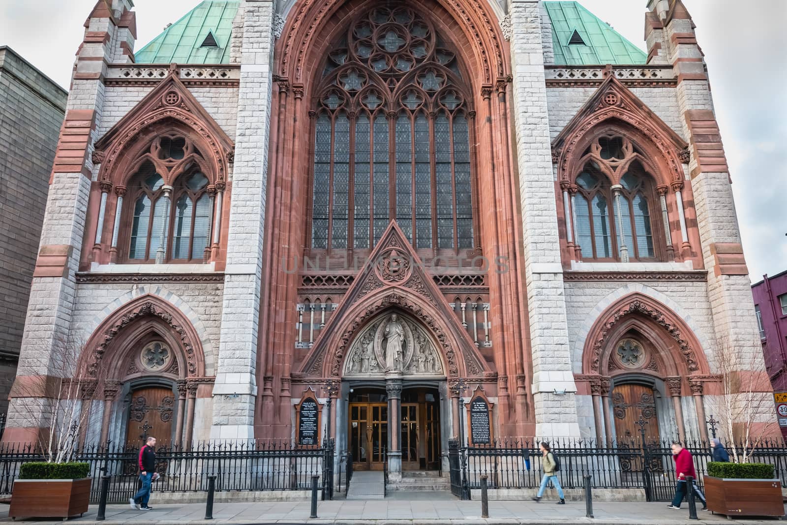 Dublin, Ireland - February 13, 2019: Street atmosphere and architecture of St. Augustine and St. John The Baptist Catholic Church that people visit on a winter day