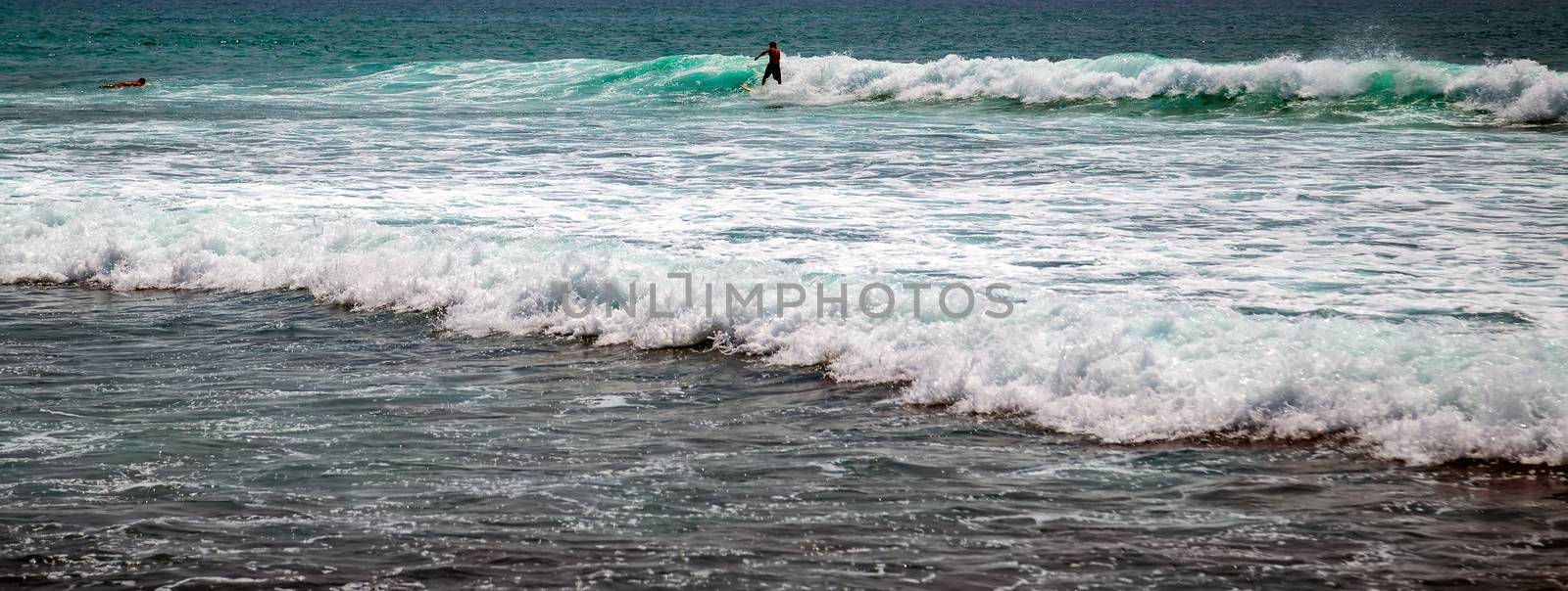 Surfer on a surfboard in the sea water splash blue transparent surf fresh ocean water background island of Bali Indonesia.