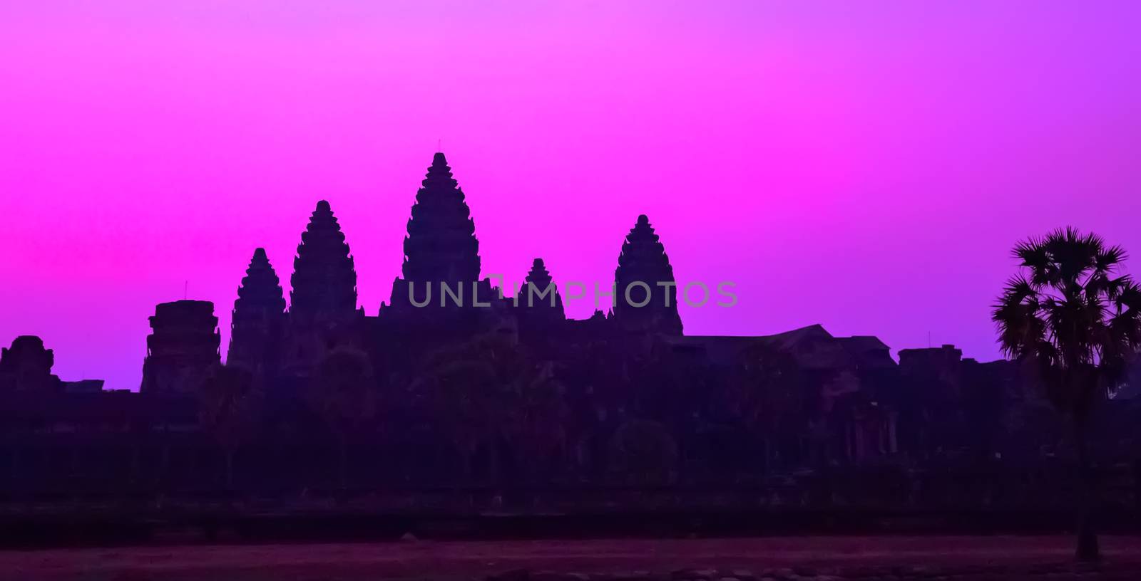 Panorama Mist sunrise tropical morning violet mauve sky landscape tourist attraction temple facade silhouette of the UNESCO Angkor Wat temple in Angkor Archaeological Park Siem Reap Cambodia.