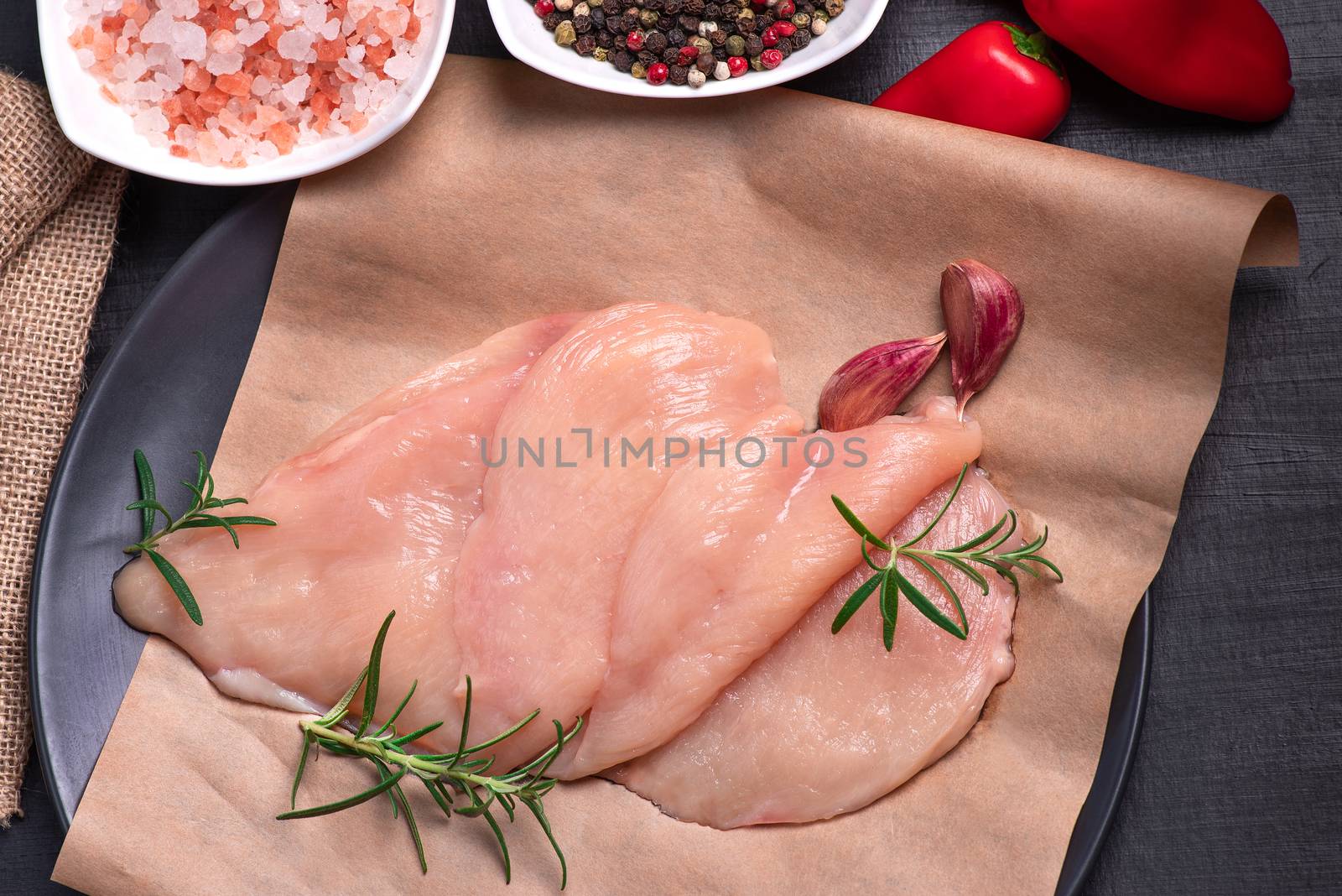 Raw chicken slices on a wooden table with raw vegetables and spices. Satilisimo. fresh, choped and sliced chicken meat. Cooking,raw sliced chicken breast.Top view. by nkooume