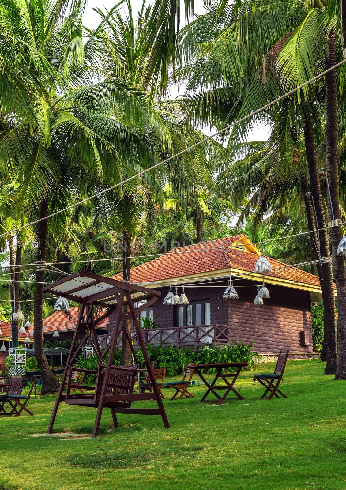 Tropical beach resort with bamboo hut and coconut trees