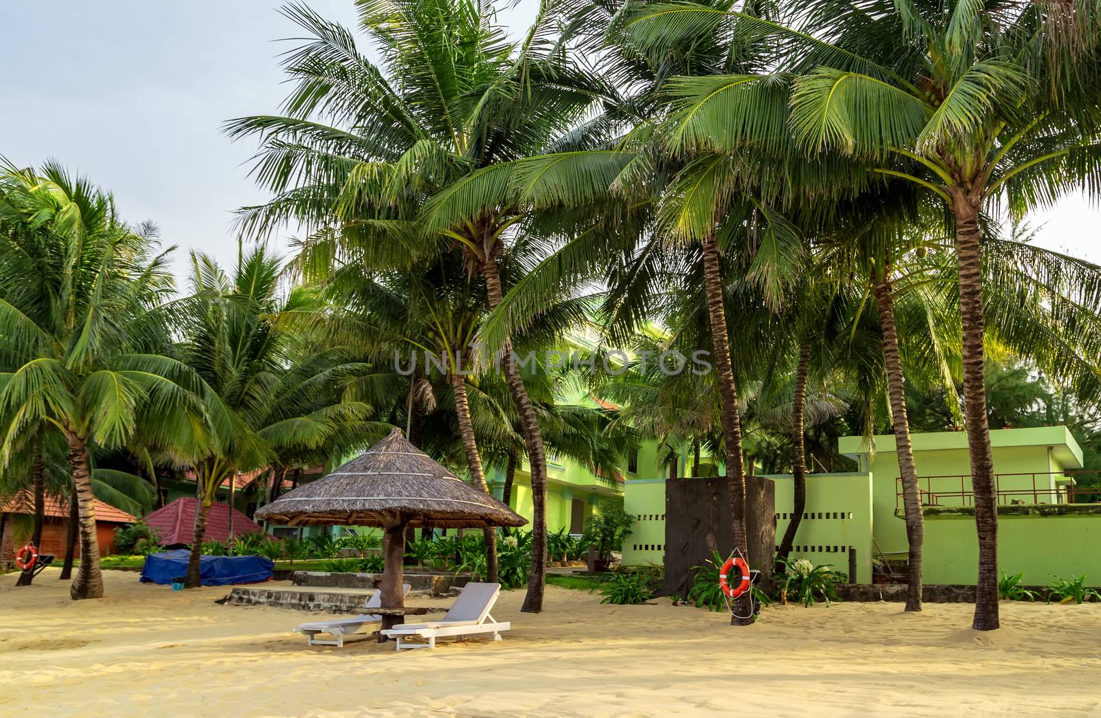 Tropical views from Long Beach Phu Quoc Island, Vietnam. Nobody on the beach. Palm tree bamboo umbrellas and sun chairs in background.