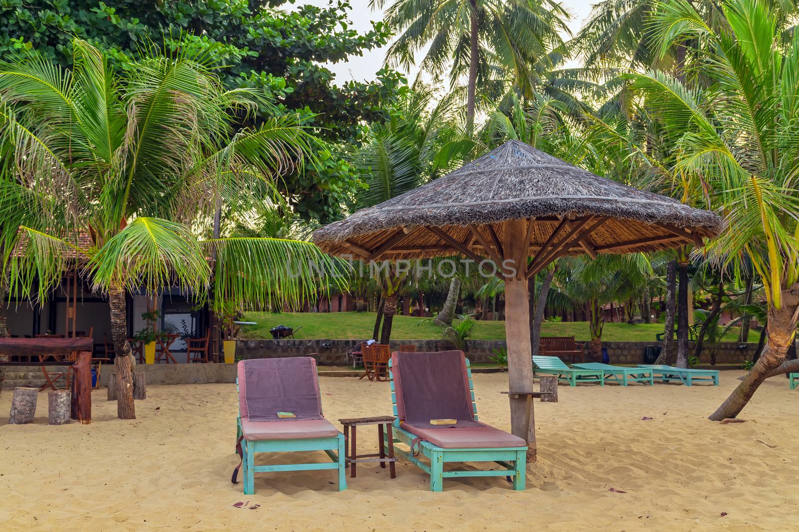 View of resort beach with golden sand, umbrellas and chairs. Summer landscape. Beautiful tropical place in Vietnam. Vacation holidays summer background.