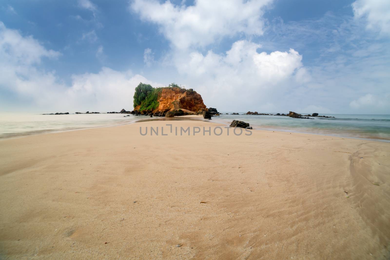 sandy tropical beach, front of the viewpoint on orange rock where you can see both sides of Mirissa bay, Sri lanka