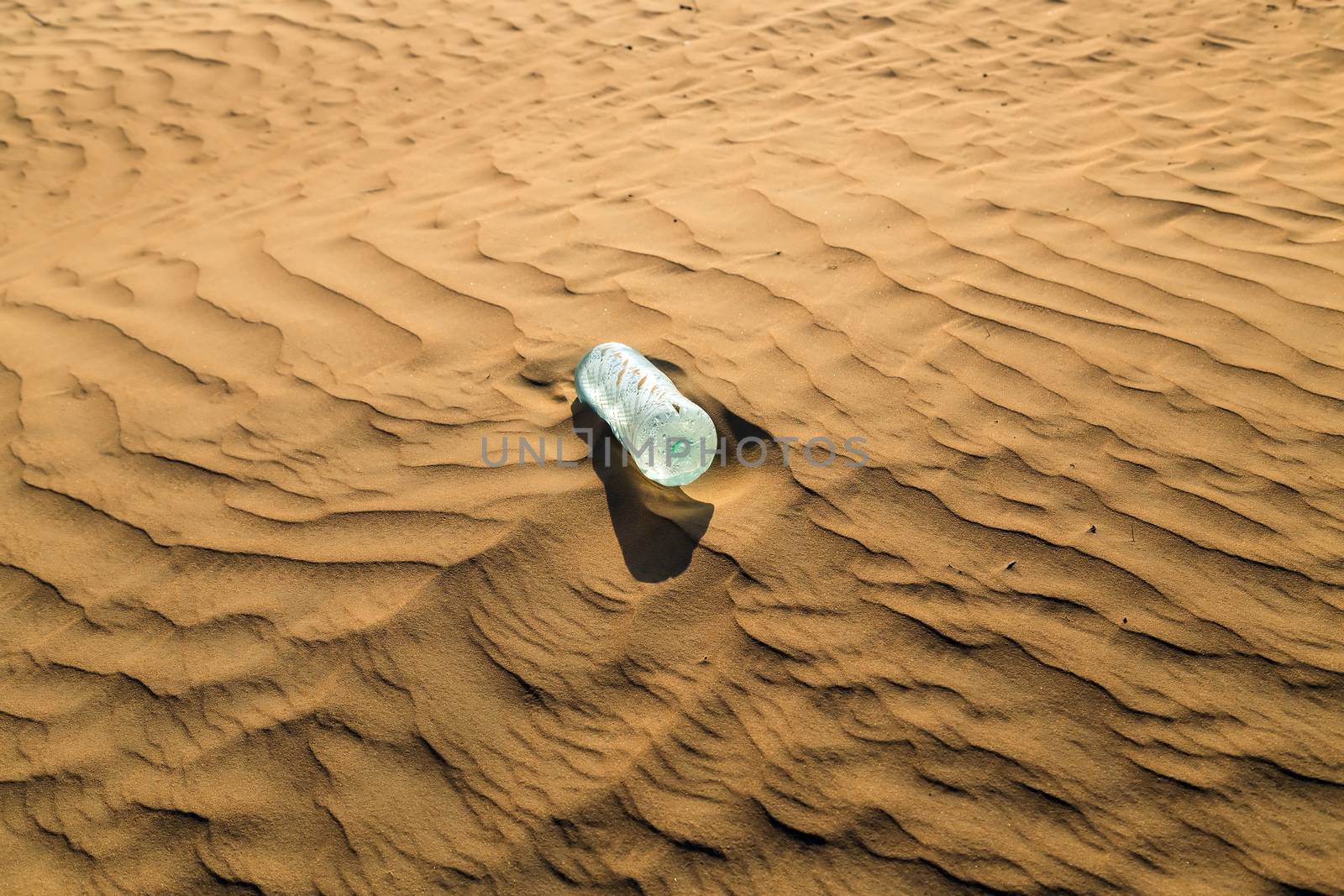 water bottles in sand dunes eco concept nature landscape desert