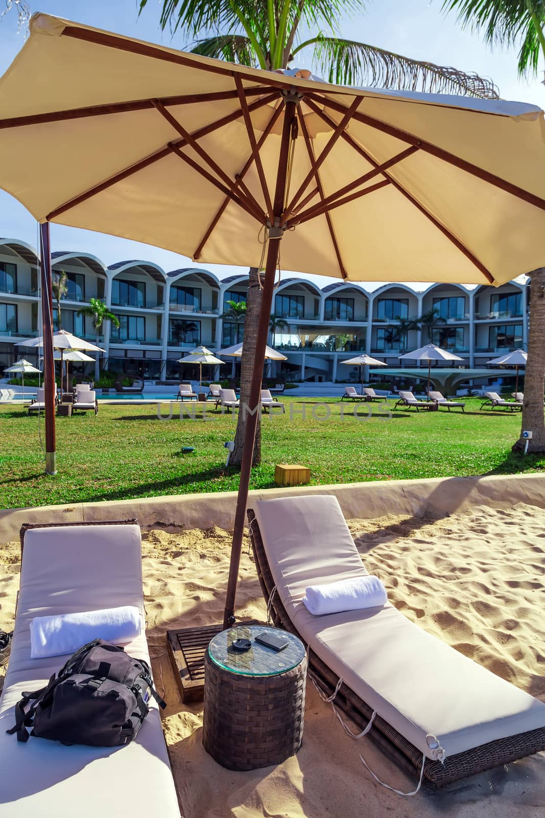 Relax On The Summer Beach landscaped outdoors furniture of wood table with beach sunshade shelter to suit all weather, comfortable chairs. Phu Quoc island in Vietnam.