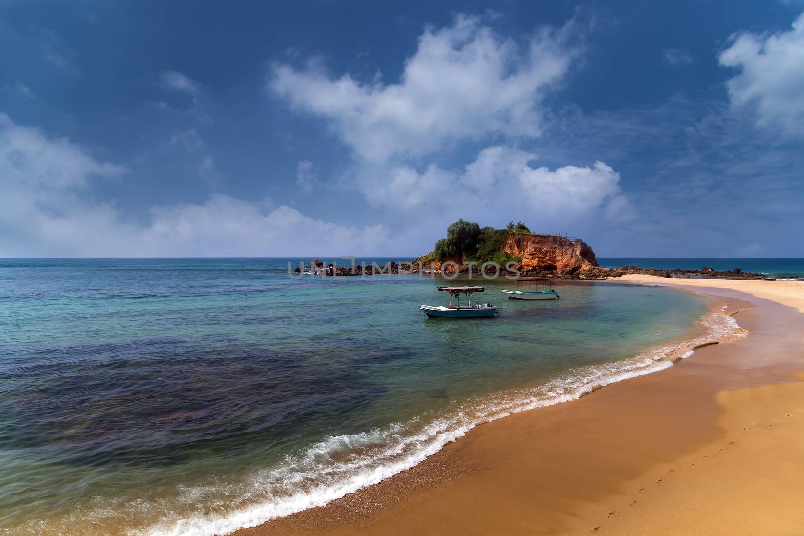 Island Parrot Rock Mirissa beach is our favourite beaches in Sri Lanka. Summer sandy beach with blur ocean on background.