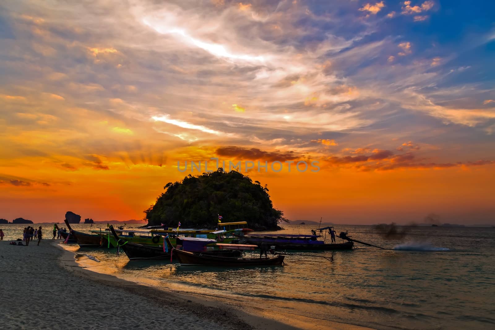 traditional longtail boats, rocks, cliffs, tropical beach. Krabi, Thailand. Beauty Scene or sun over colorful sky with clouds Seascape. Tourism travel