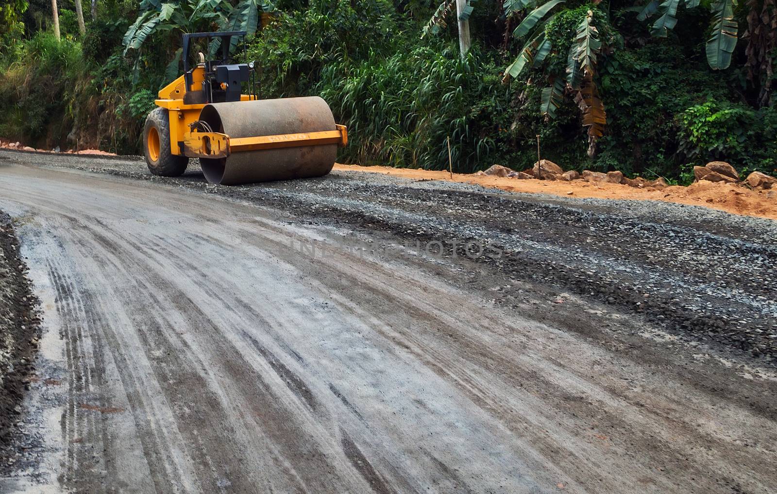 Road vibration roller, Construction site of a new highway in jungle rainforest, steamroller machine and asphalt finisher
