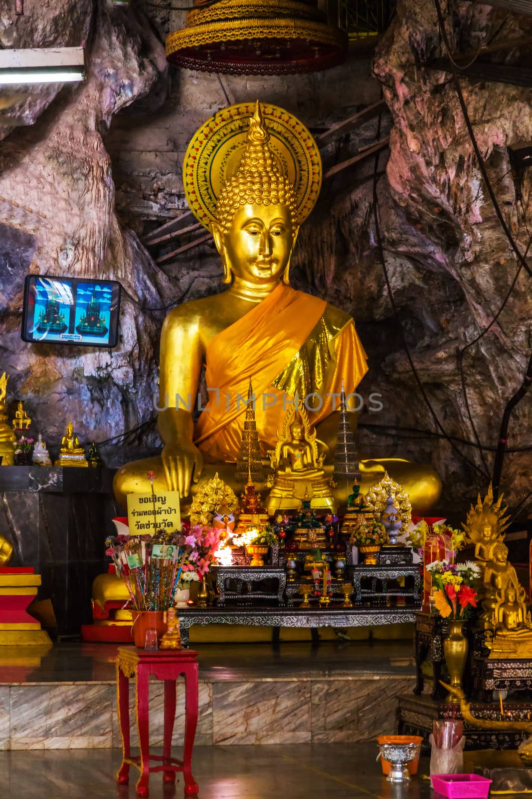 Stone statue of Buddha sitting in lotus pose gold-plated.