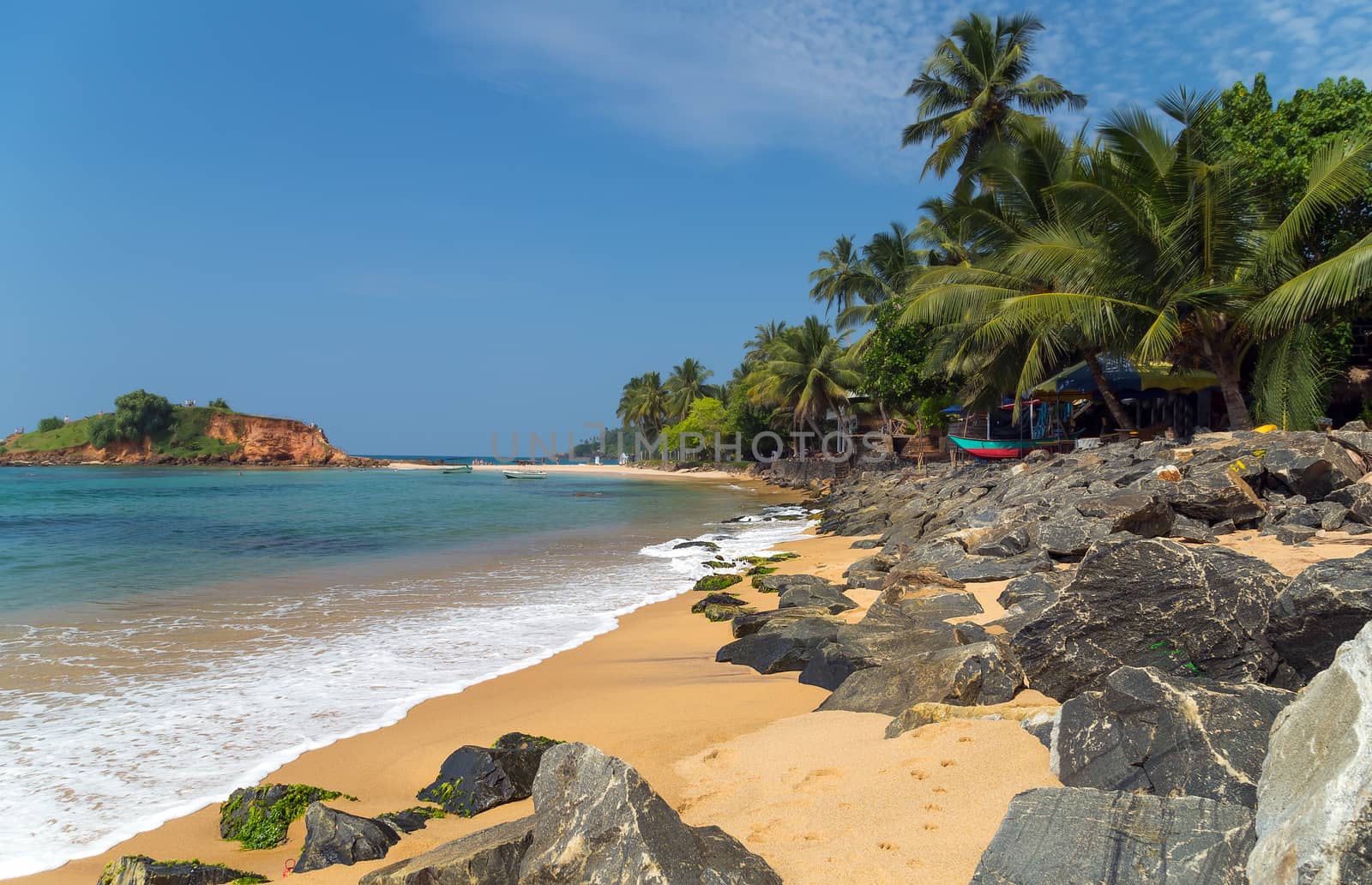 Beautiful bay with white sand beach, blue water and big boulders, Parrot Rock Mirissa Sri Lanka