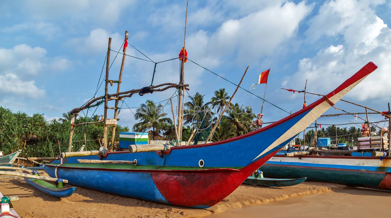 Sri Lankan traditional fishing catamarans, Colorful fishing boats on a long sandy beach on the ocean coast of Sri Lanka.