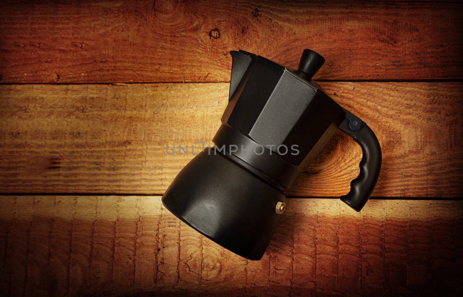 Black Italian coffee maker isolated on wooden background by SlayCer