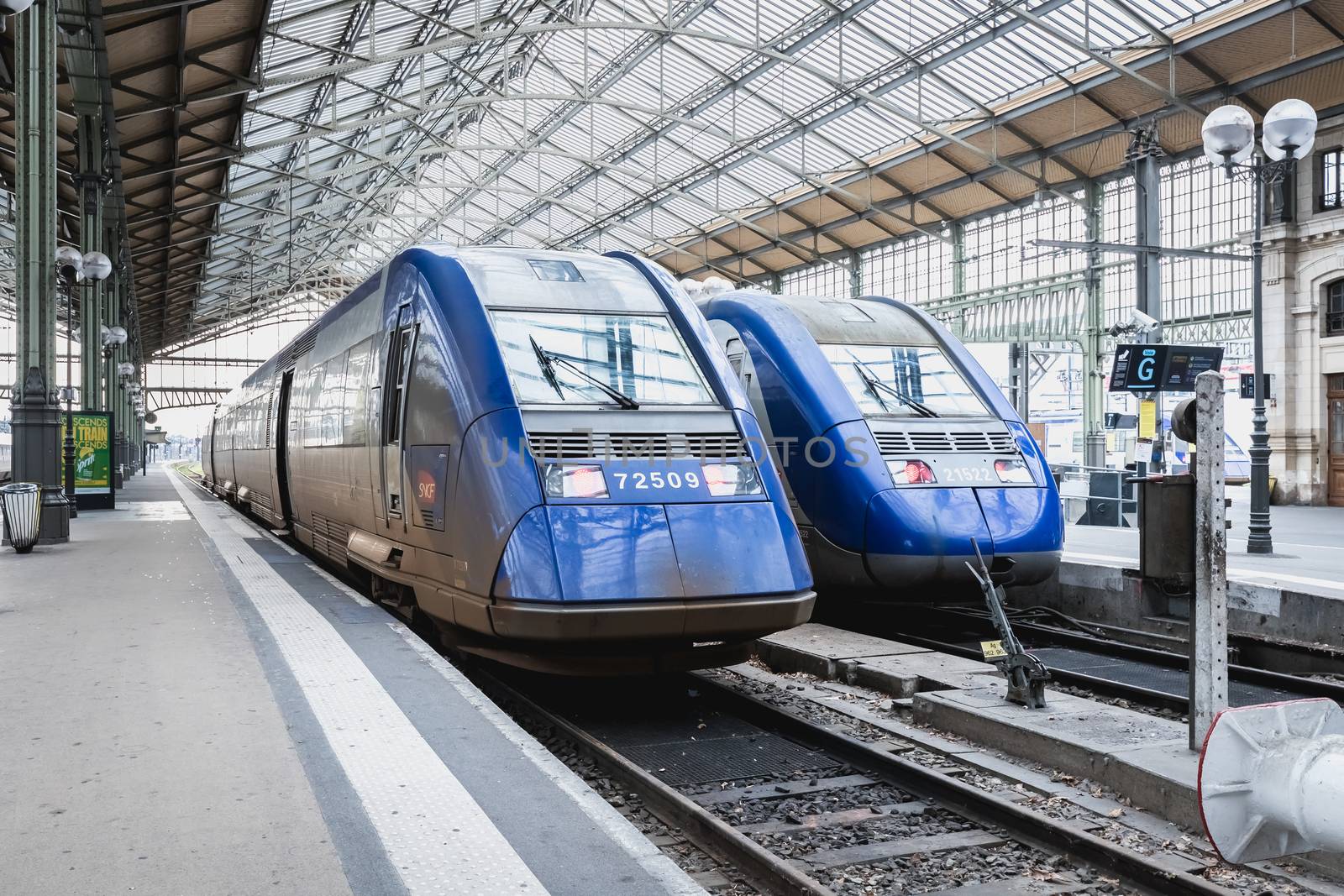 Tours, France - February 8, 2020: train at platform where people walk inside Tours train station in the city center on a winter day