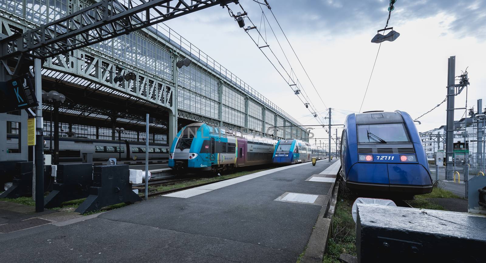 Tours, France - February 8, 2020: train at platform where people walk inside Tours train station in the city center on a winter day