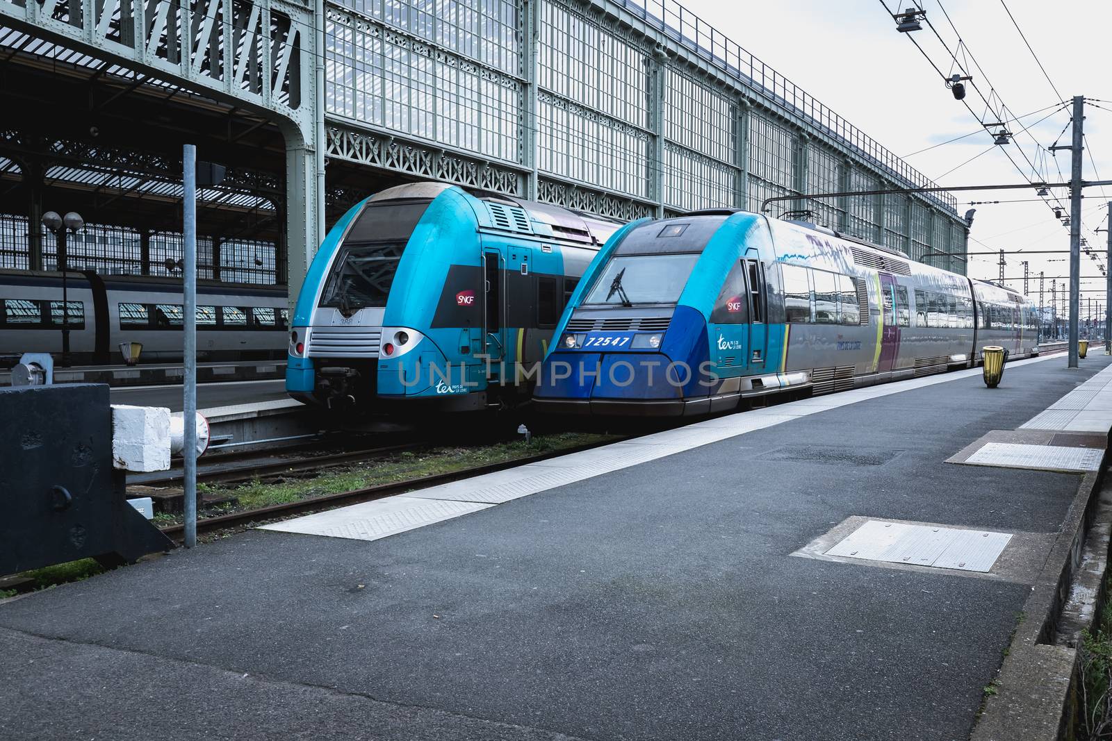 Tours, France - February 8, 2020: train at platform where people walk inside Tours train station in the city center on a winter day