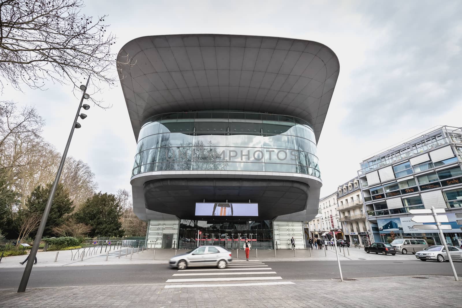 Tours, France - February 8, 2020: people passing the city convention center on a winter day in bad weather. Building designed by Jean Nouvel with Yves Brunier, landscaper