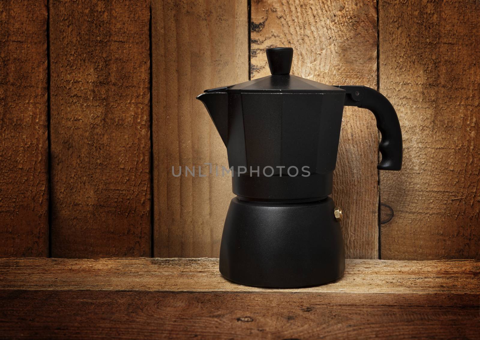 Black Italian coffee maker isolated on wooden background by SlayCer