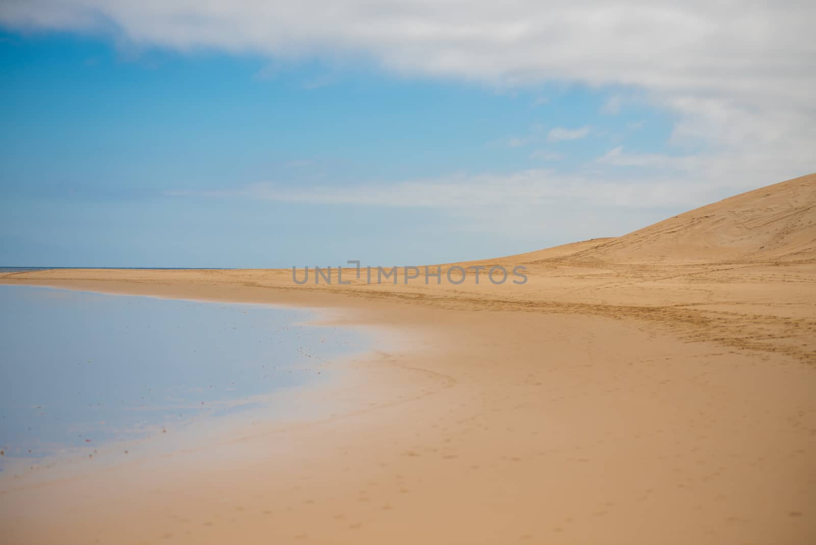 Landscape shot of sanddune with blue sky by rushay