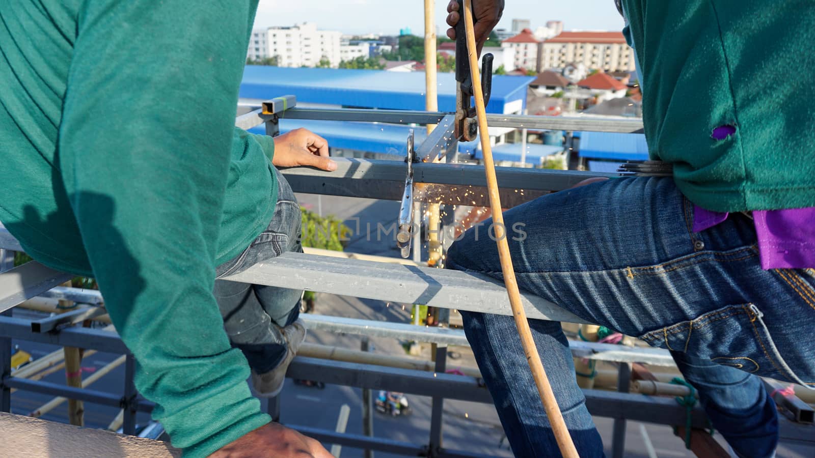 Welding of metal structures with soldering steel beam structure on extension of a building on construction site. Sparks and smoke fly as steel is welded. by sonandonures