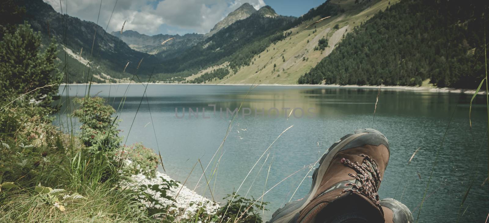 hiker taking a break sitting near the lake of Oule in valley of Aure in Haute-Bigorre in the department of Hautes-Pyrénées in France