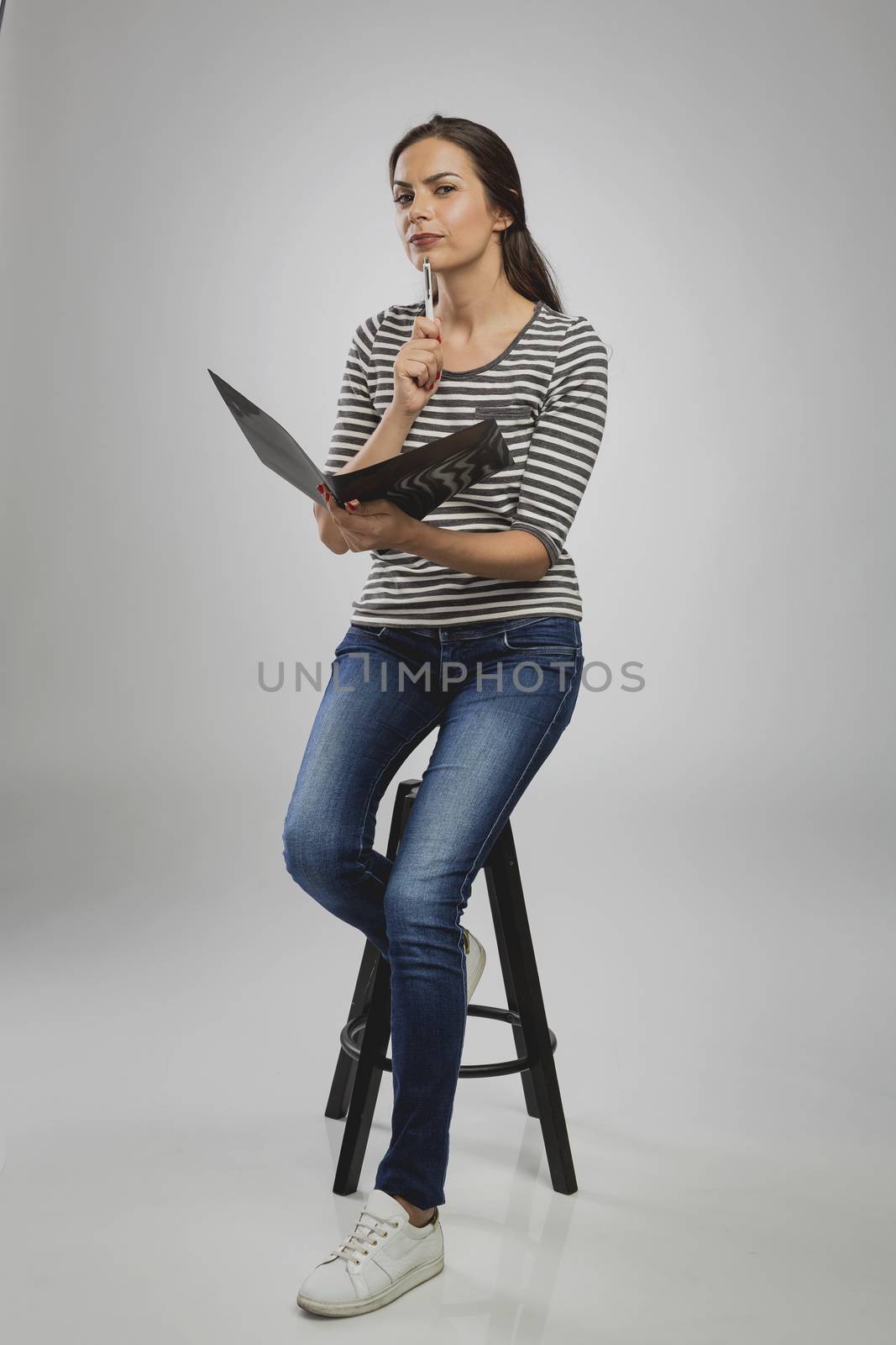 Beautiful woman sitting on a bench holding a folder and thinking







Woman sitting on a bench while think