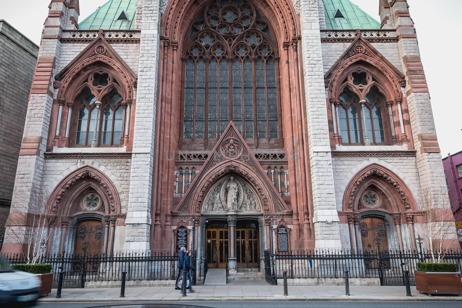 Dublin, Ireland - February 13, 2019: Street atmosphere and architecture of St. Augustine and St. John The Baptist Catholic Church that people visit on a winter day