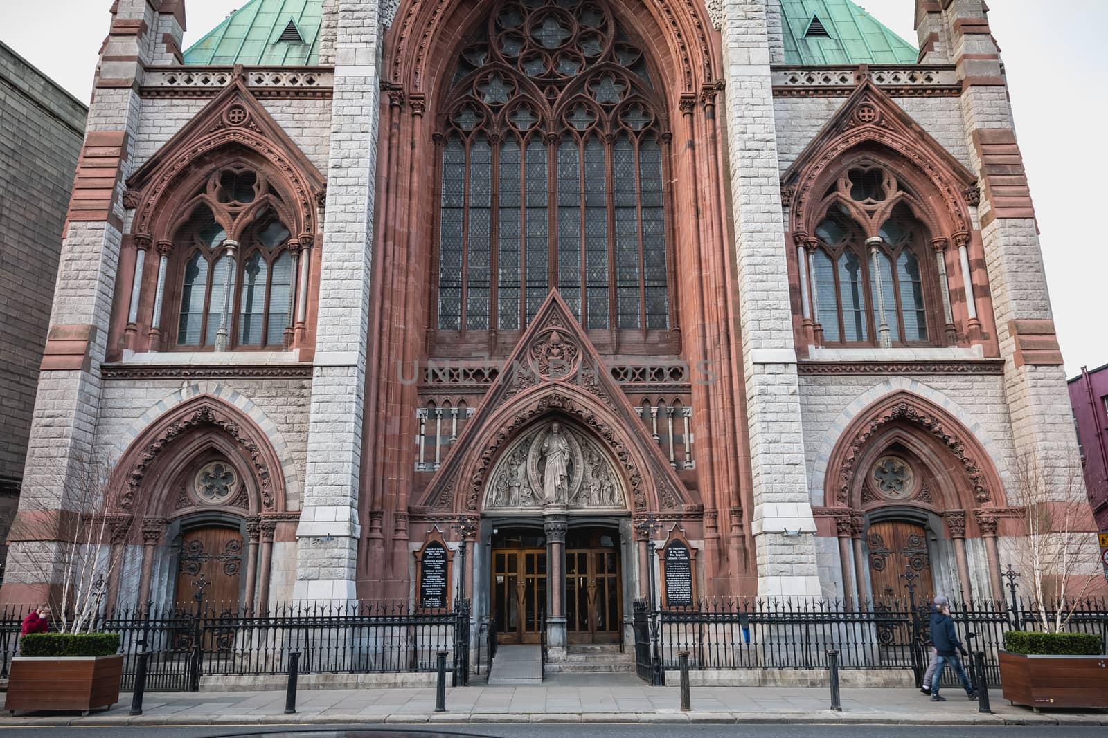 Dublin, Ireland - February 13, 2019: Street atmosphere and architecture of St. Augustine and St. John The Baptist Catholic Church that people visit on a winter day