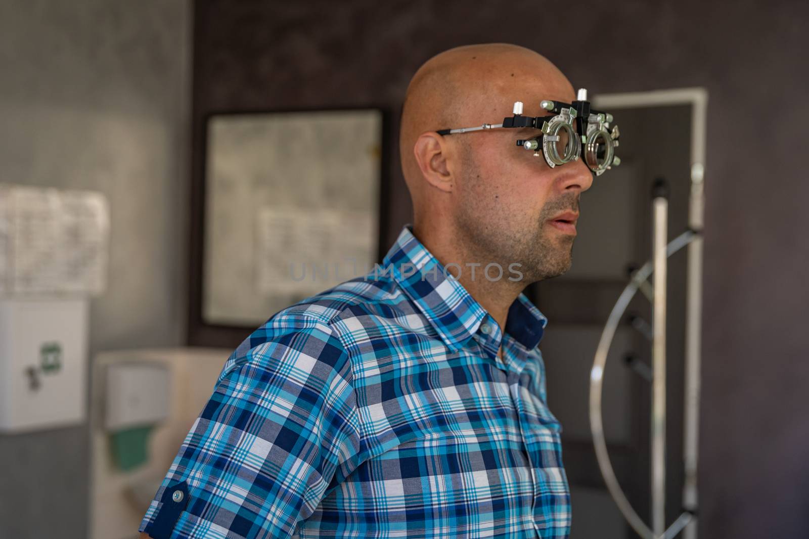 vision measurement by optometrist at clinic, young man as patient.