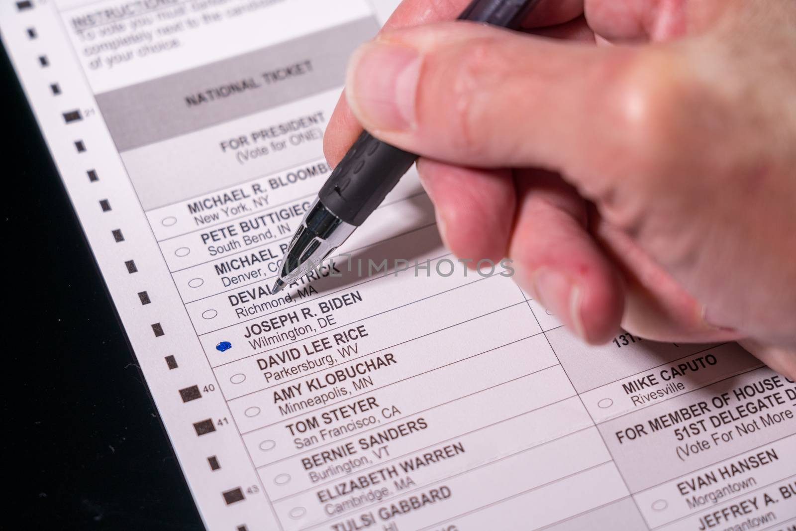 Morgantown, WV - 21 May 2020: Democratic primary election absentee ballot form with hand holding pen for Joe Biden for President