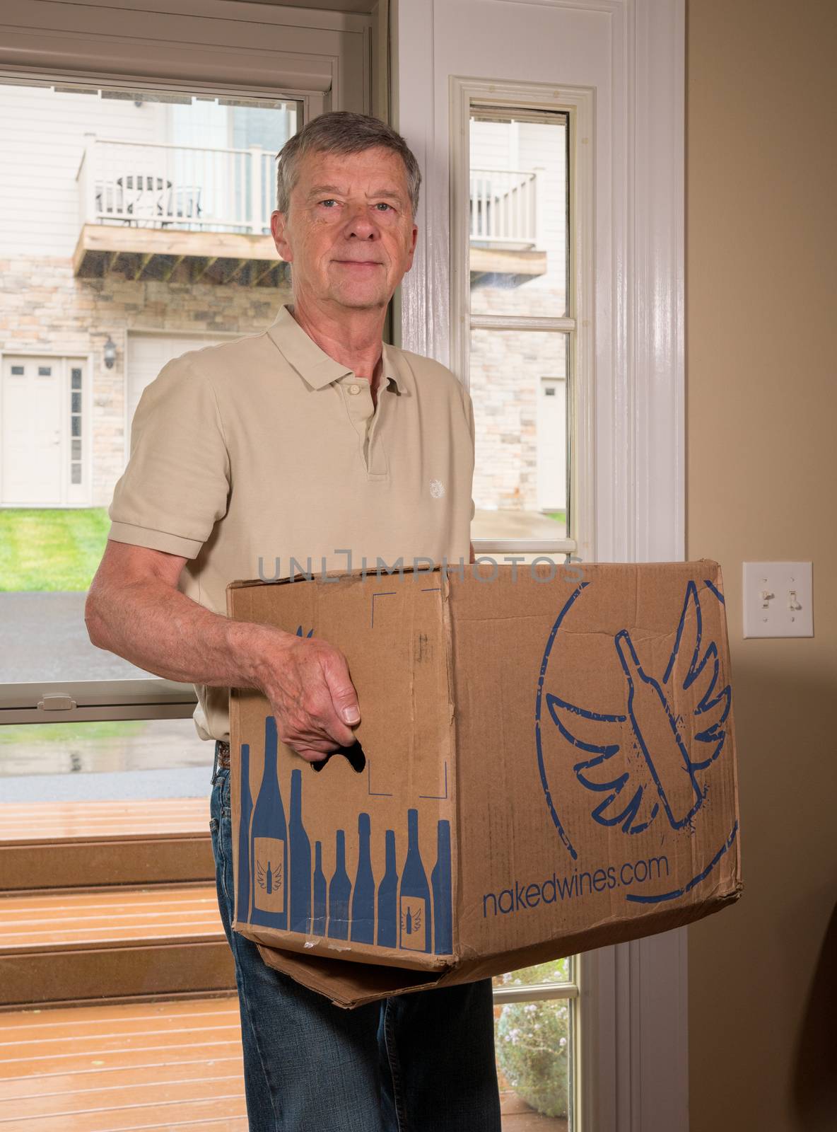 Morgantown, WV - 19 May 2020: Man carrying delivery case of a dozen wine bottles from Naked Wines into home